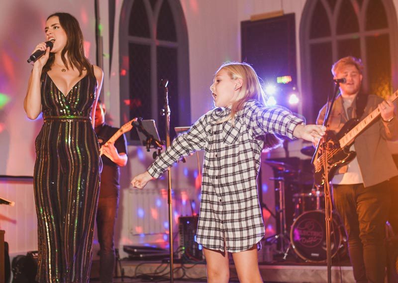 Georgie on stage with young girl at birthday party in Hythe, Kent